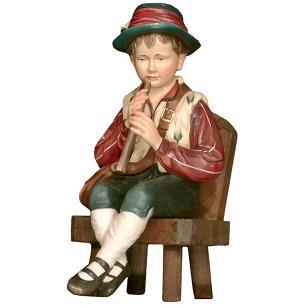 Ragazzo che suona il flauto su sedia